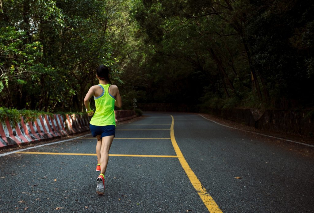 Healthy lifestyle fitness woman runner running on mountain road